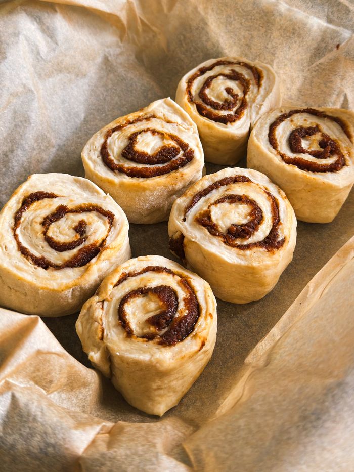 Close-up of six delicious cinnamon buns, ready for baking.