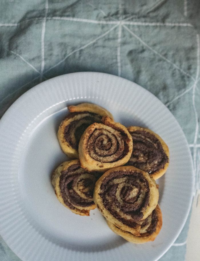 A close-up view of freshly baked cinnamon rolls on a white plate, ideal for food enthusiasts.